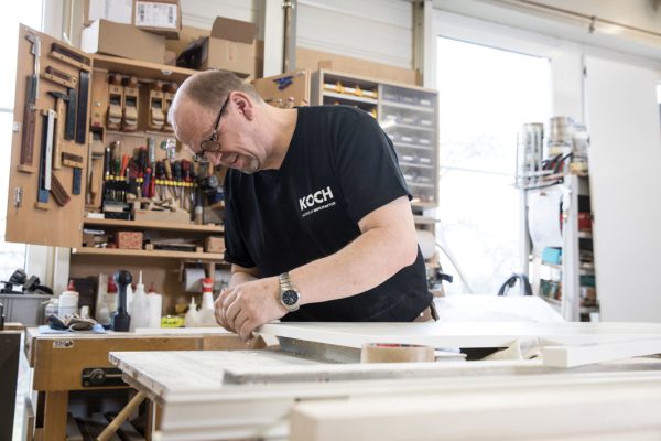 Koch Mitarbeiter verarbeitet Holzplatte